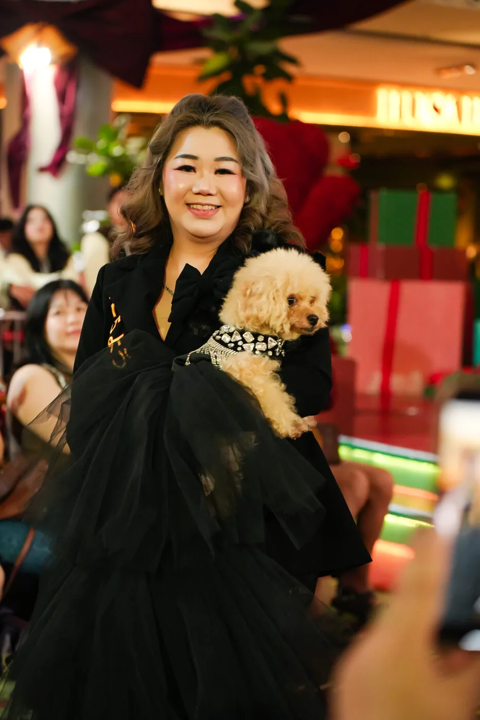 Owner carrying her dog at an event